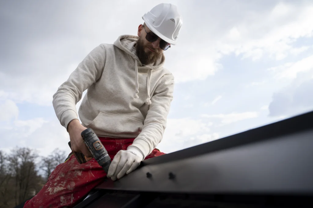 Professional gutter installation service with metal gutters on residential roof in Garland, TX
