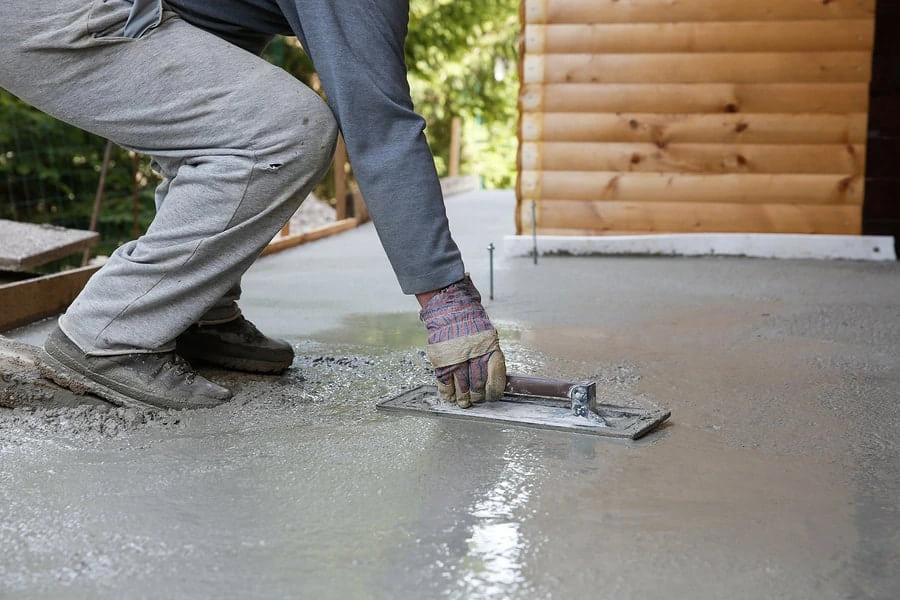 Contractor finishing concrete surface after mudjacking repair in Garland, TX