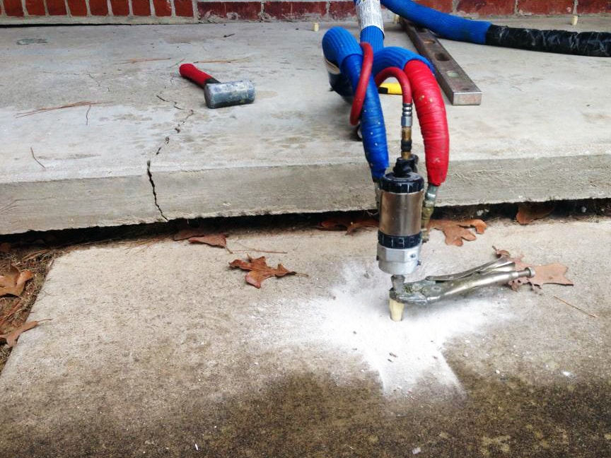 Polyurethane foam injection in Garland, TX lifting cracked concrete slab with specialized equipment