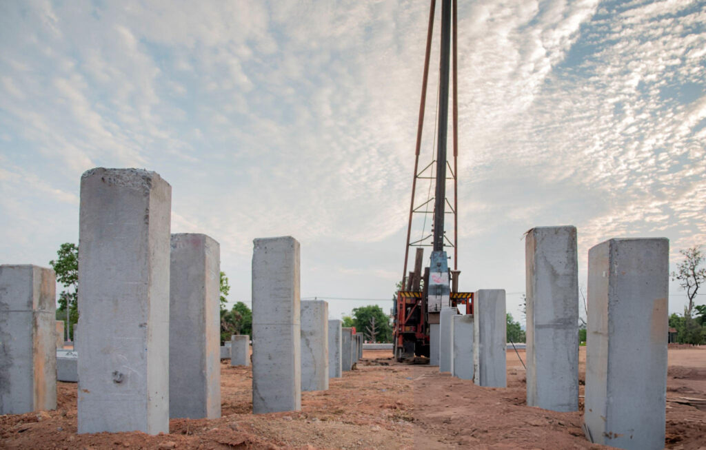 Pressed concrete pilings installation in Garland, TX with hydraulic piling equipment on job site