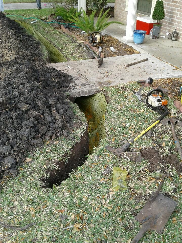 Contractor installing root barrier near home foundation to prevent root damage in Garland, TX