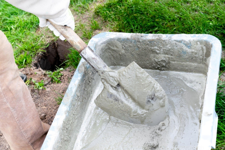 Slurry grouting service in Garland, TX with contractor mixing cement grout for foundation injection