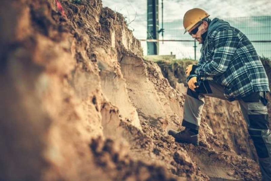 Soil engineer inspecting soil composition for stabilization project in Garland, TX